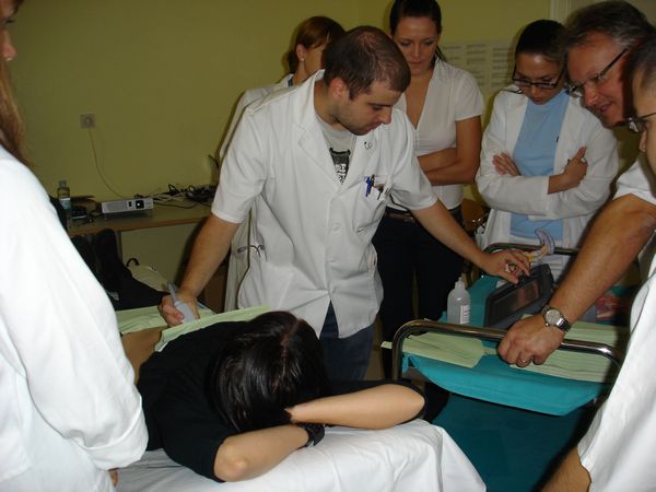 Na sliki je študent, ki demonstrira ultrazvočni pregled trebuha